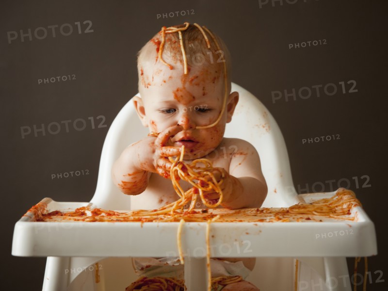 Baby covered in spaghetti. Photographer: Mike Kemp