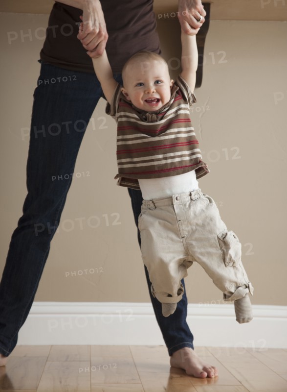 Mother swinging toddler. Photographer: Mike Kemp