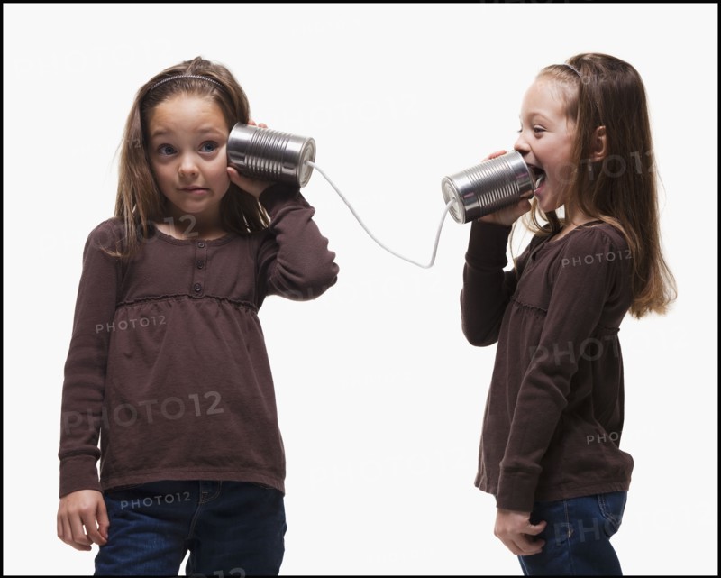 Girls playing with tin can phones. Photographer: Mike Kemp
