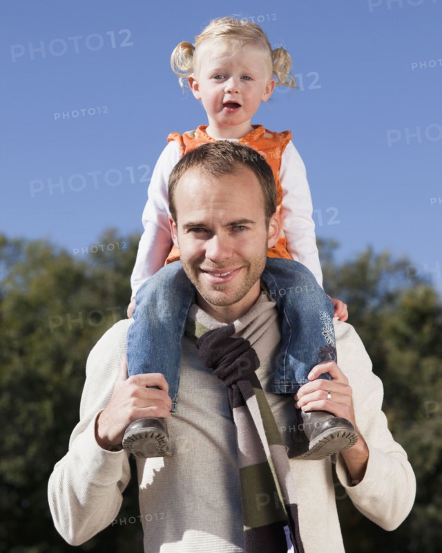 Father holding daughter on his shoulders. Photographer: Mike Kemp