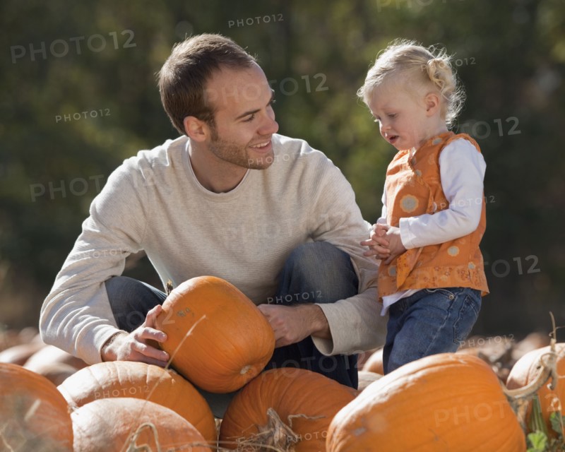 Father and daughter in pumpkin patch. Photographer: Mike Kemp