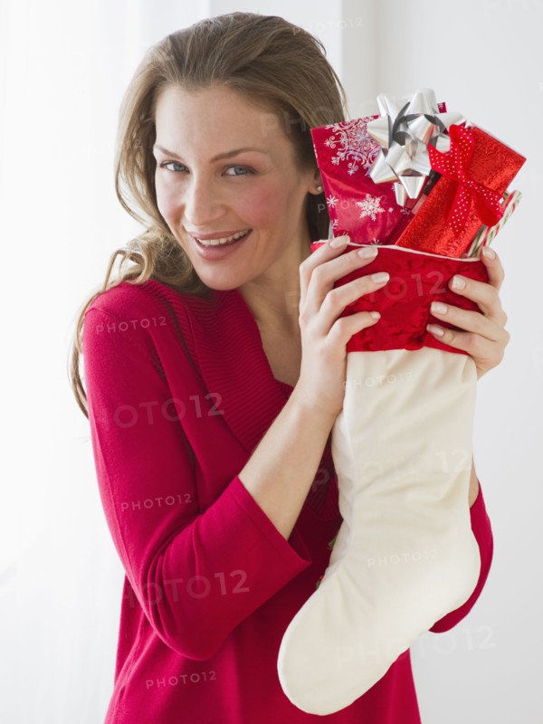 Woman holding Christmas stocking.