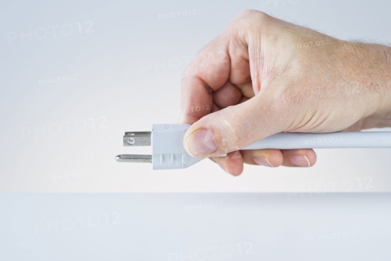 Hand holding plug.