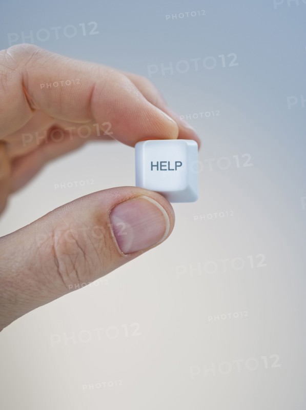 Hand holding keyboard help key.