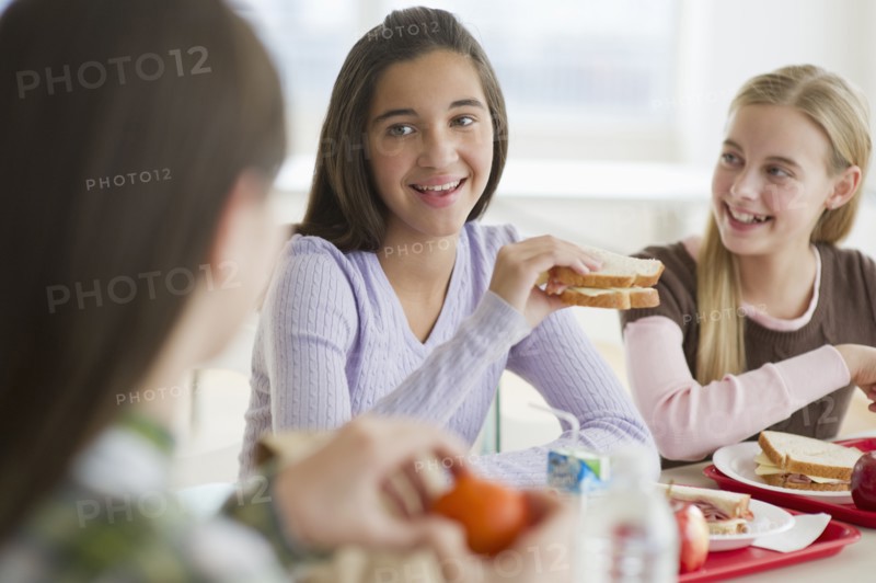 Friends eating in cafeteria.
