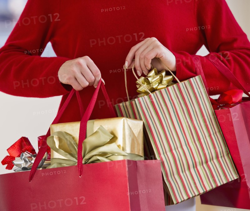 Woman holding bags of gifts.