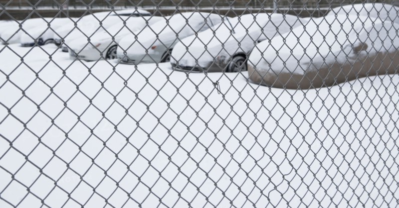 Parking lot behind chain link fence. Photographer: fotog