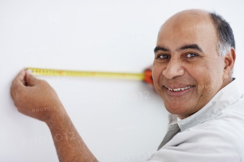 Man measuring wall. Photographer: momentimages