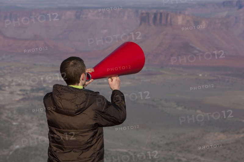 Man using megaphone at top of canyon. Photographer: Dan Bannister