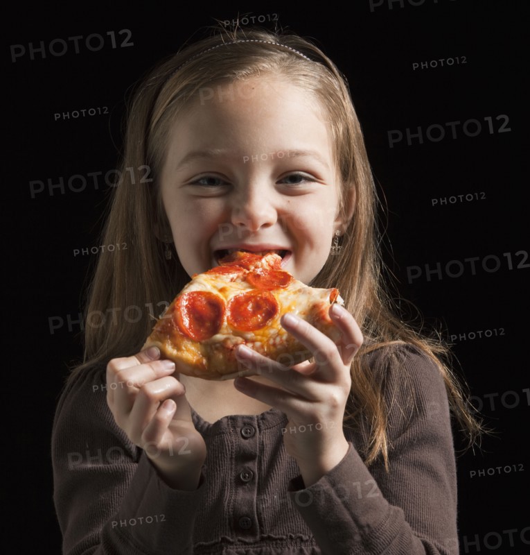 Young girl eating pizza. Photographer: Mike Kemp
