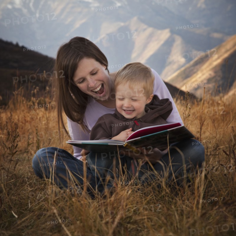 Mother and son reading outdoors. Photographer: Mike Kemp
