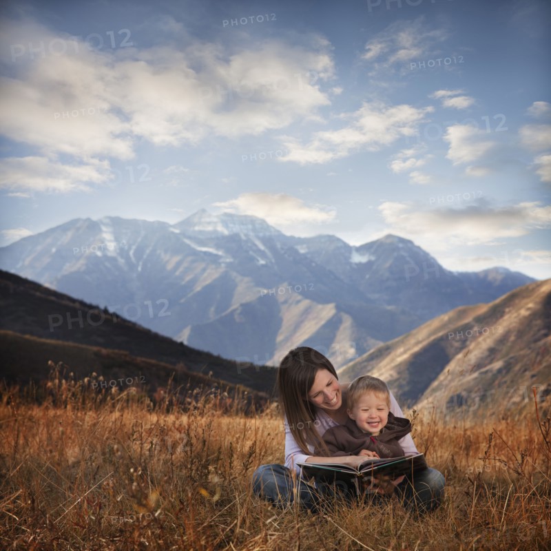 Mother and son reading outdoors. Photographer: Mike Kemp