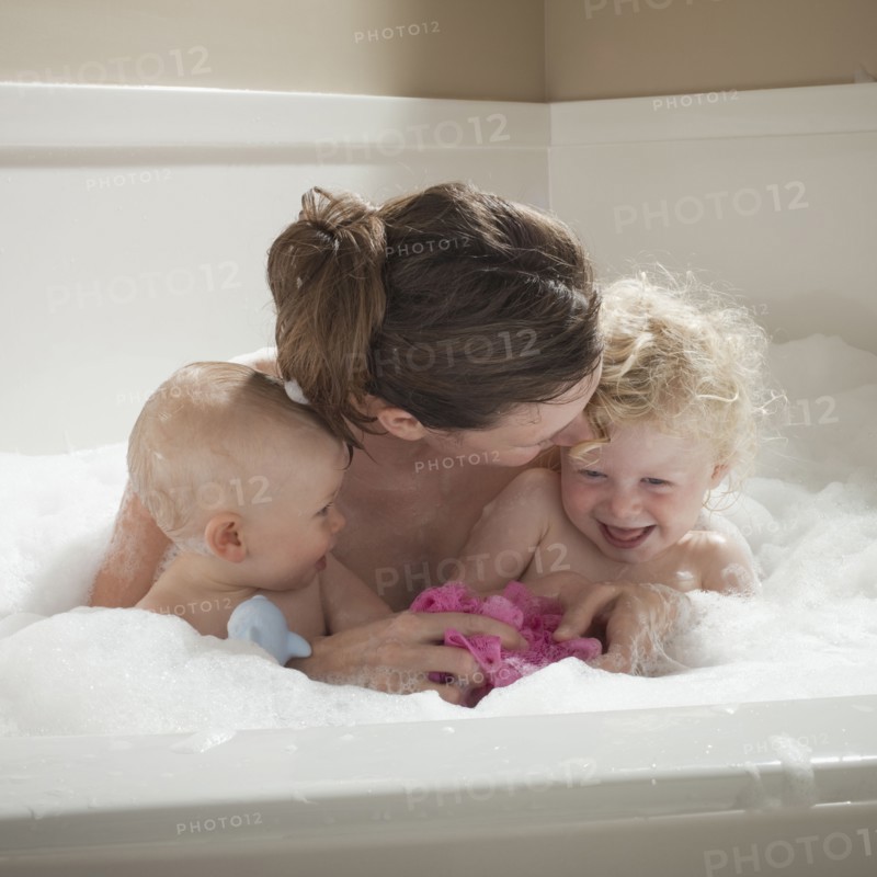 Mother and children having bubble bath. Photographer: Mike Kemp