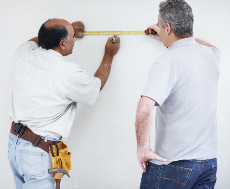 Men measuring wall. Photographer: momentimages