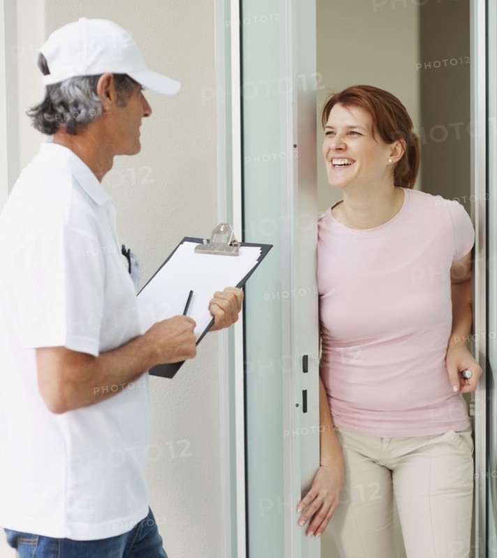 Woman talking to man at the door. Photographer: momentimages