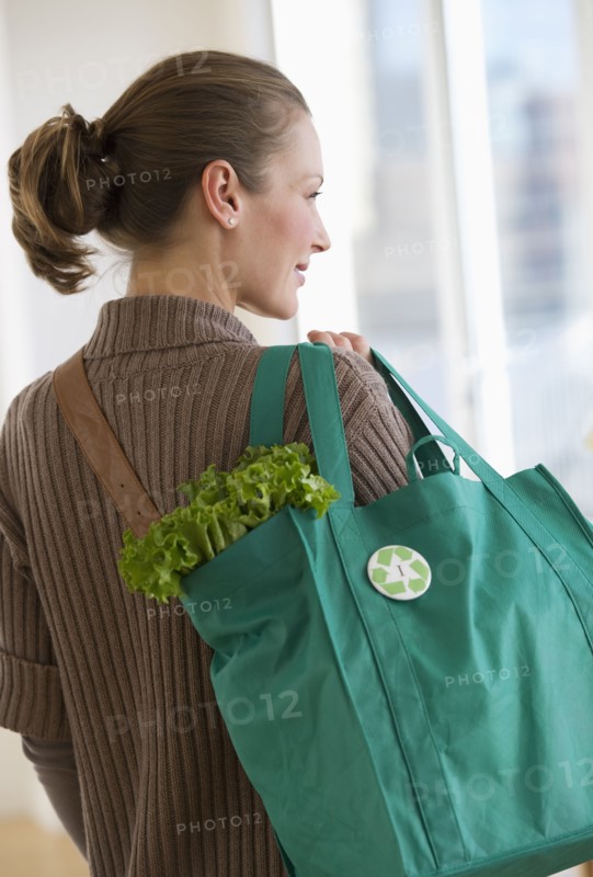Woman carrying bag of groceries.