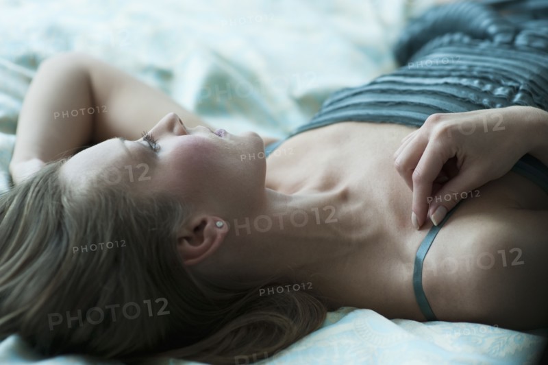 Woman lying down on bed.
