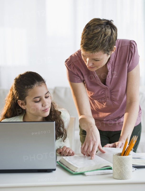 Mother helping daughter with her homework.