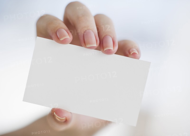 Hand holding a blank business card.