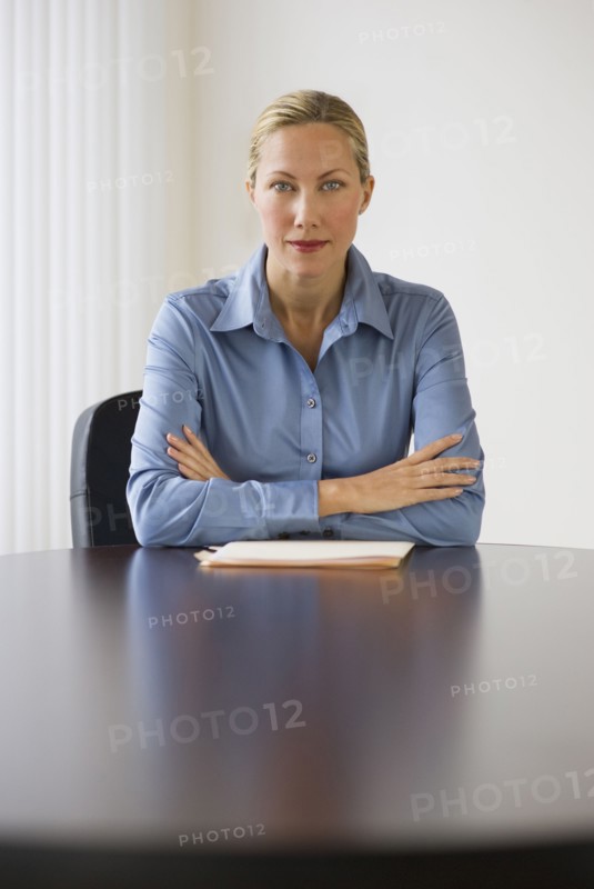 Businesswoman sitting at conference table.