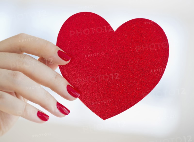 Hand holding red heart.