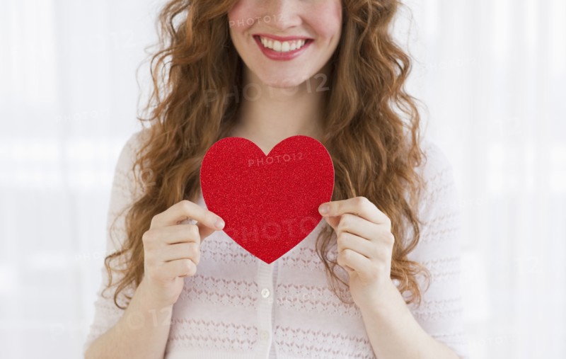 Woman holding a red heart.