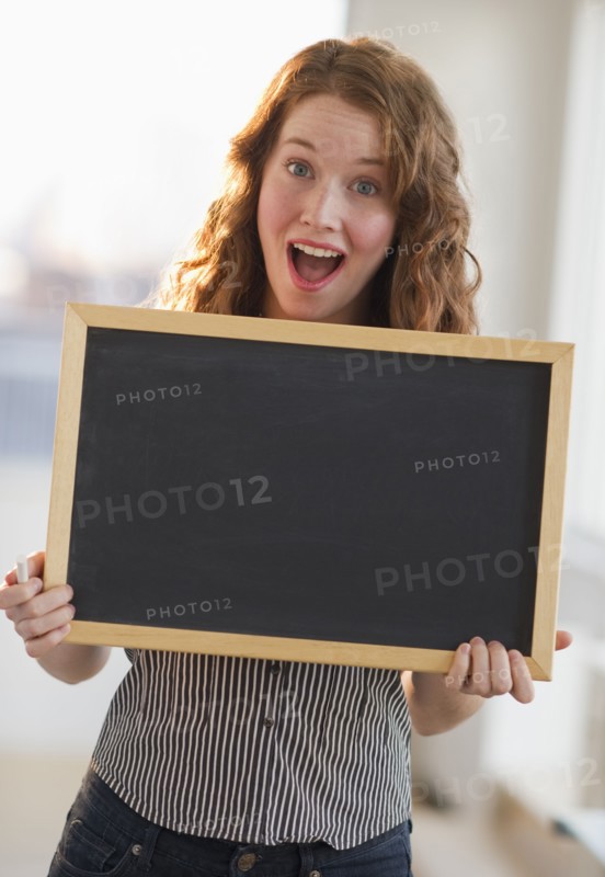 Woman holding a blank chalkboard.