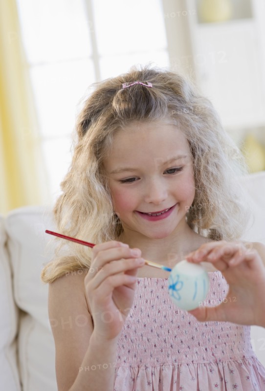 Young girl decorating an Easter egg.