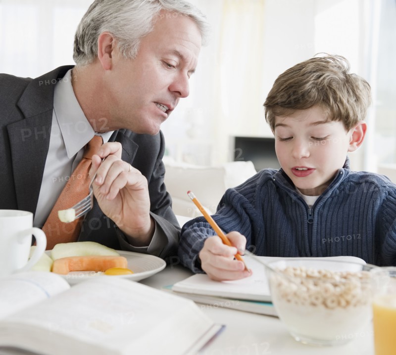 Father helping son with homework. Photographe : Jamie Grill