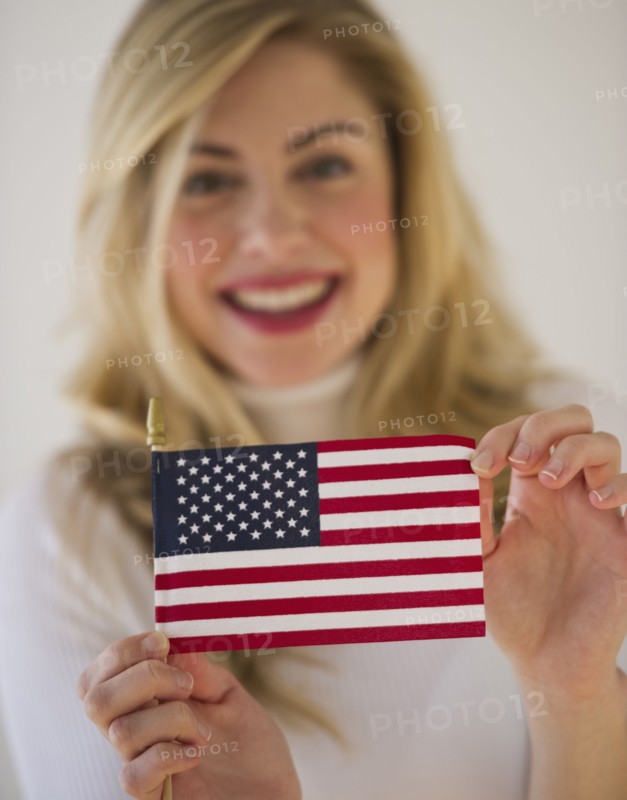 Young woman holding American flag. Photographe : Daniel Grill