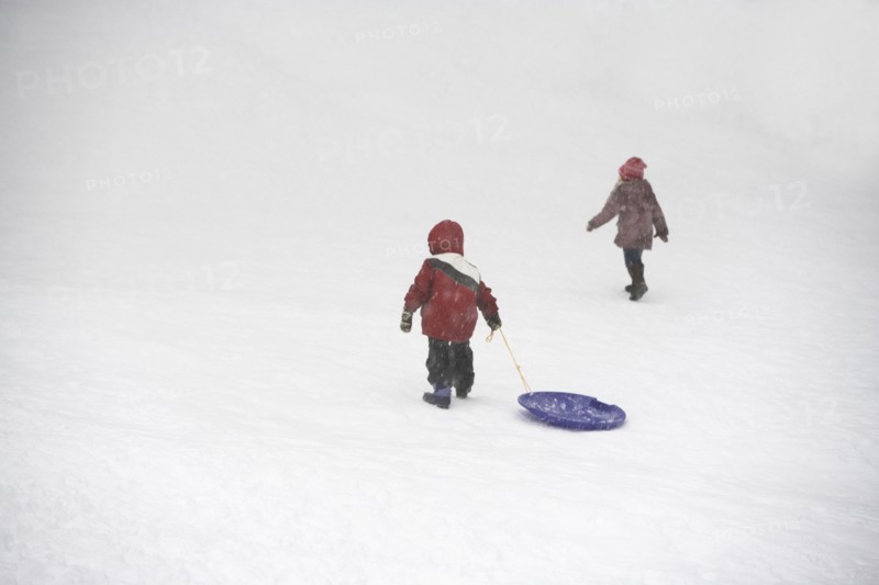 Kids pulling sled up snowy hill. Photographe : fotog