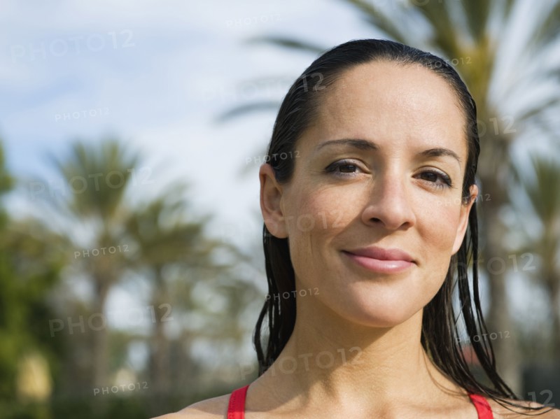 Woman standing in front of palm trees.