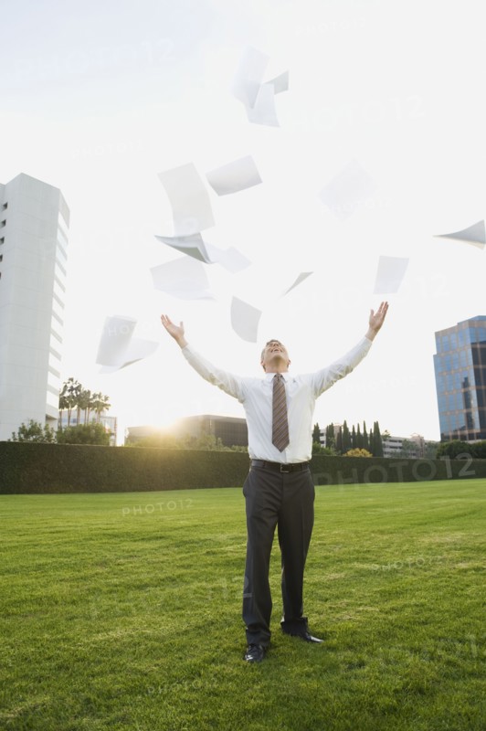 Businessman throwing papers in air.