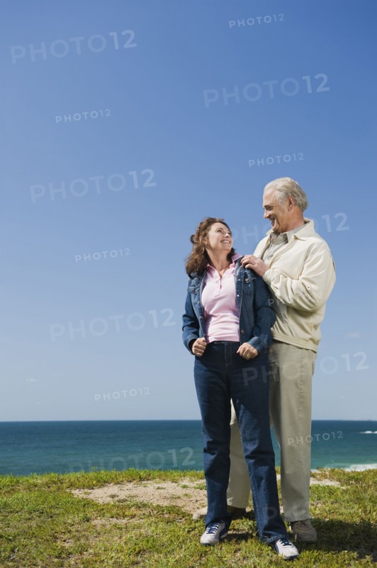 Couple standing near the ocean.