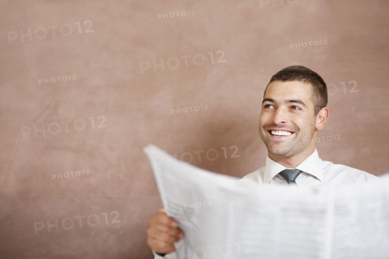 Businessman reading newspaper. Photographe : momentimages