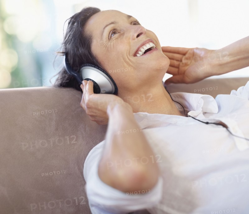 Woman listening to music on headphones. Photographe : momentimages