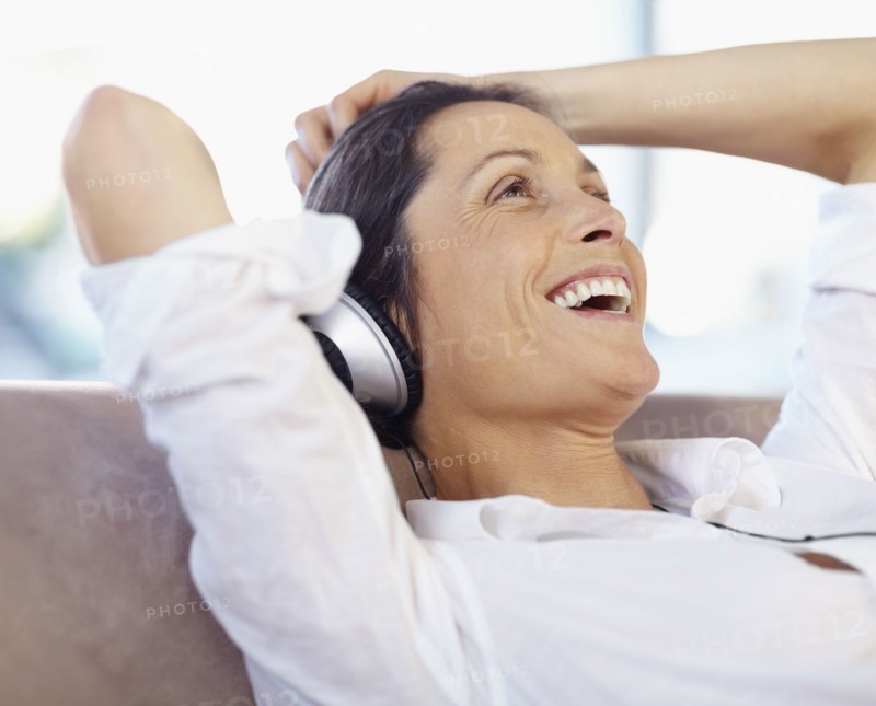 Woman listening to music on headphones. Photographe : momentimages