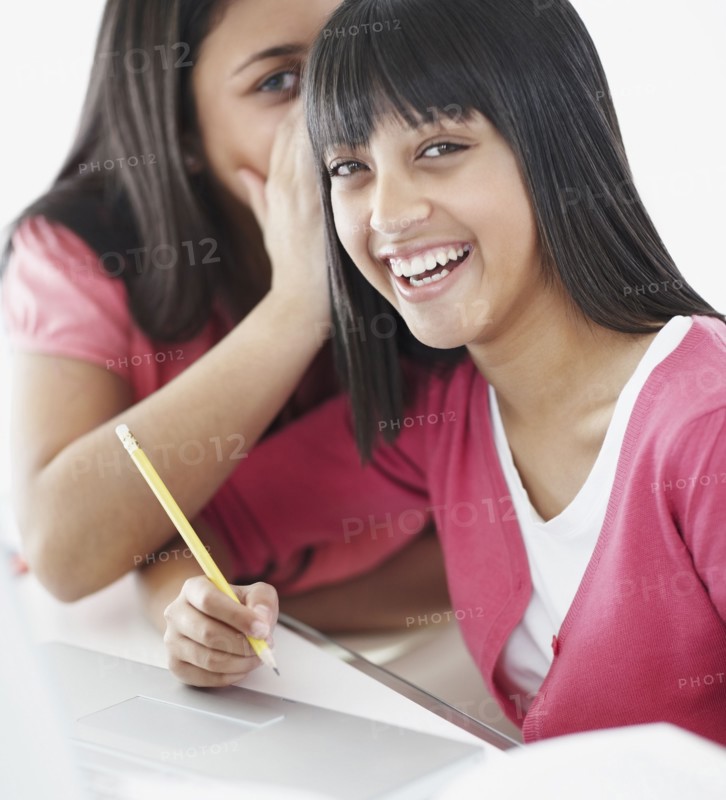 Students whispering in classroom. Photographe : momentimages