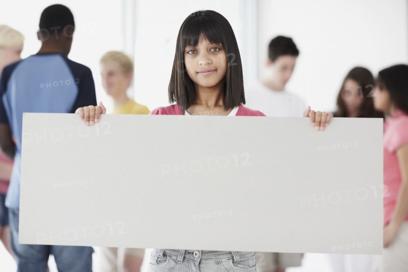 Young student holding blank billboard. Photographe : momentimages