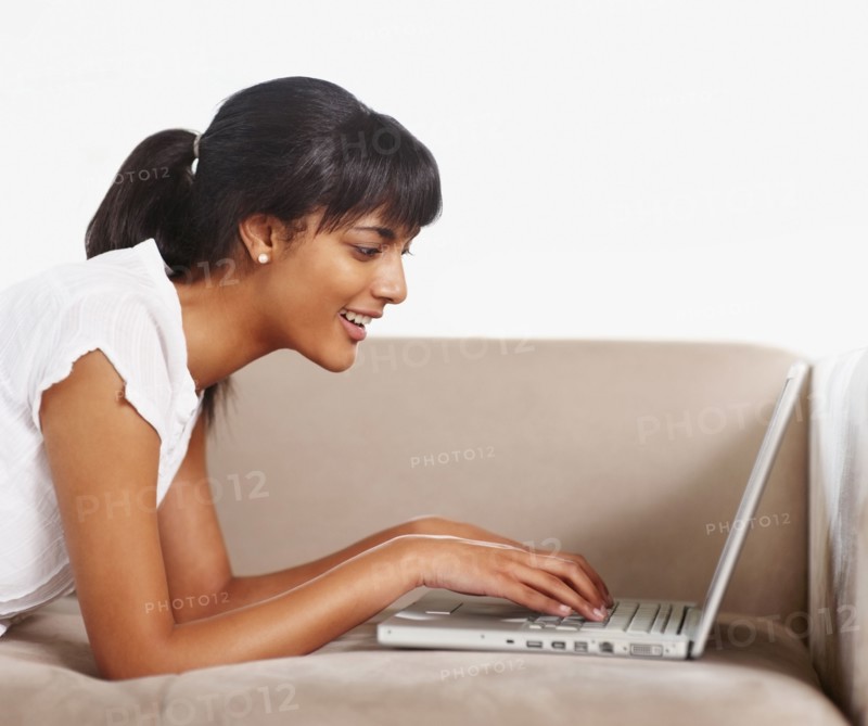 Young woman typing on laptop. Photographe : momentimages