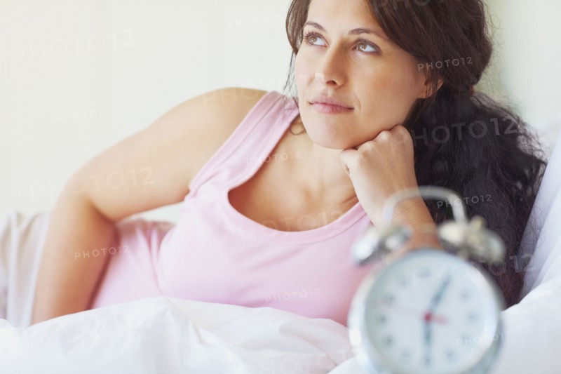 Woman thinking in the bedroom. Photographe : momentimages