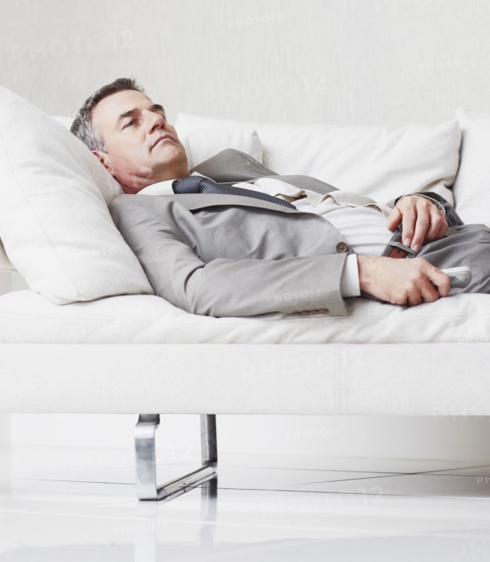 Businessman resting on couch. Photographe : momentimages