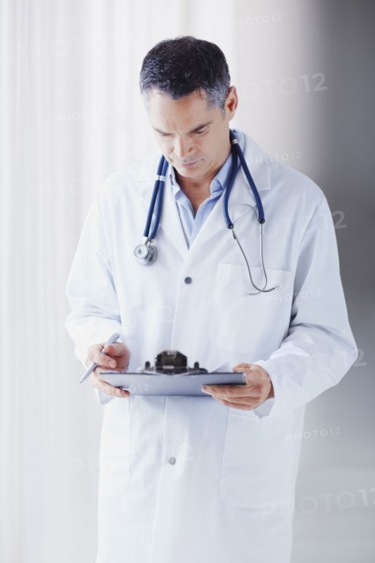 Doctor reading chart. Photographe : momentimages