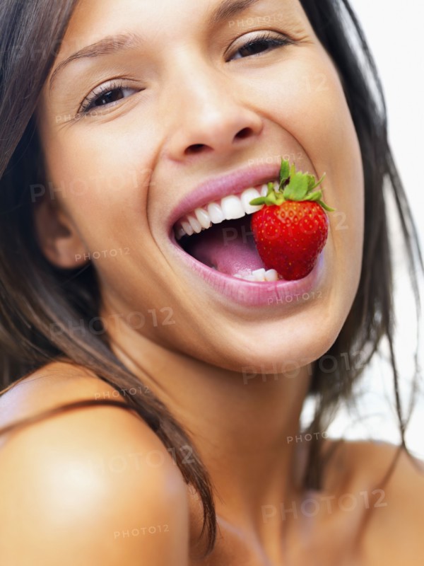 Woman eating strawberry. Photographe : momentimages