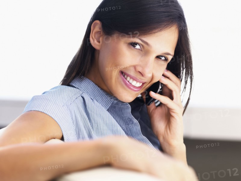 Woman talking on cellular phone. Photographe : momentimages