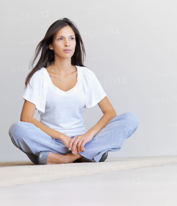 Woman sitting cross legged on floor. Photographe : momentimages