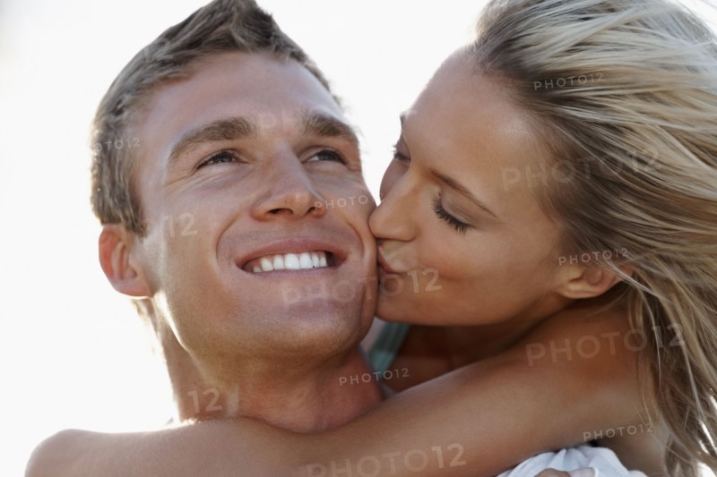 Man giving girlfriend a piggy back ride. Photographe : momentimages