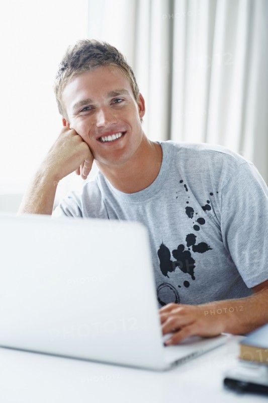 Young man working on laptop. Photographe : momentimages