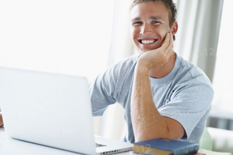 Young man working on laptop. Photographe : momentimages