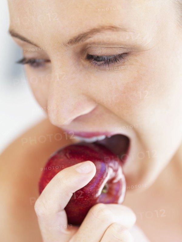 Woman eating an apple. Photographe : momentimages
